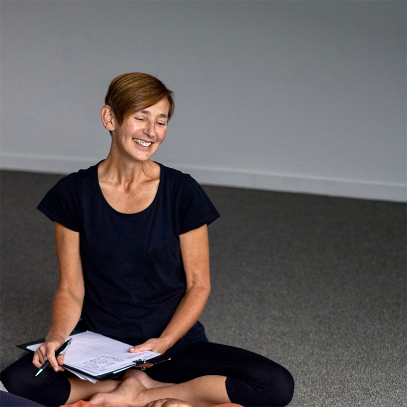 smiling woman on floor with notepad