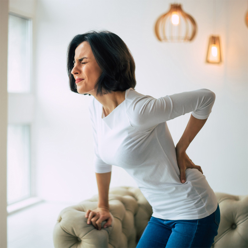 woman hand on lower back in pain